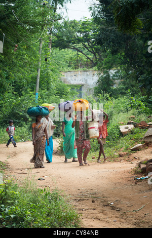 Il gruppo di donne indiane che trasportano il lavaggio per un villaggio della pompa dell'acqua. Andhra Pradesh. India Foto Stock