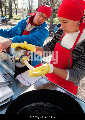 I venditori di strada che la preparazione di pasta sfoglia per rendere un Churros, Colonia del Sacramento, Uruguay Sud America Foto Stock