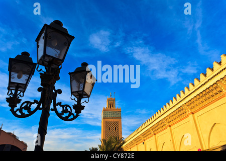 Primo piano della strada lampada esterna e la parete della moschea con minareto di Marrakech, Marocco. Foto Stock