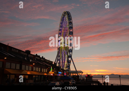 WA07728-00...WASHINGTON - la grande ruota al tramonto lungo la Seattle Waterfront area su Elliot Bay. Foto Stock