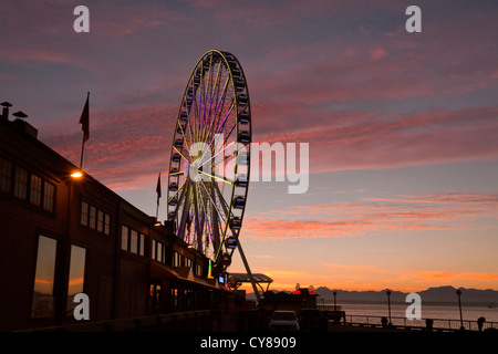 WA07730-00...WASHINGTON - la grande ruota al tramonto lungo la Seattle Waterfront area su Elliot Bay. Foto Stock