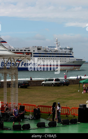 Un traghetto Brittany vele passato, voce per il porto di Portsmouth. Mentre 80's tributo atto Hairforce 5 provare per loro concerto Foto Stock