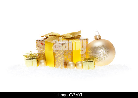 Golden Christmas gift with ribbon, golden Christmas baubles in the snow isolated on white Foto Stock