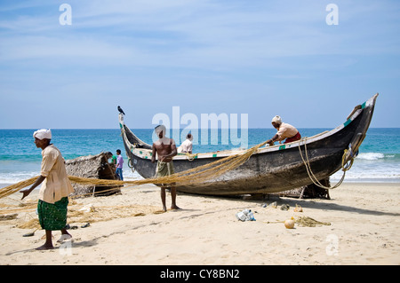 Ritratto orizzontale di pescatori mantenendo le loro reti sulla spiaggia di Kovalam, Kerala. Foto Stock