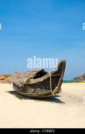 Verticale di un legno barca da pesca non in uso sulla spiaggia di Kovalam, India. Foto Stock