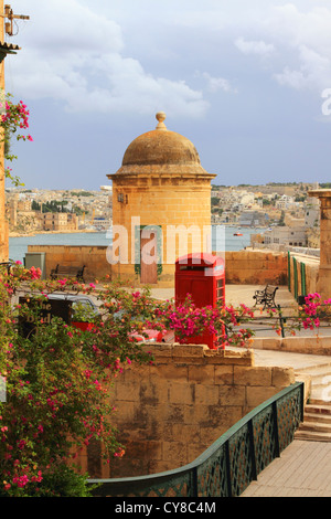 British telefono rosso kiosk nella Valletta, Malta affacciato su Port Kbir Foto Stock