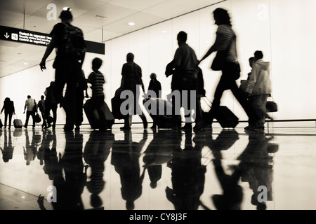 Passeggeri a piedi verso il gate di imbarco in aeroporto El Prat. Barcelona, Spagna Foto Stock