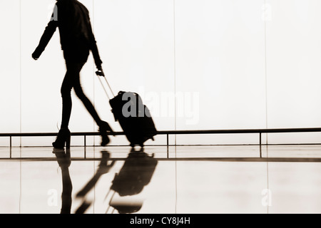 Donna con ruote bagaglio a mano in aeroporto El Prat. Barcelona, Spagna Foto Stock