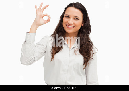 Ritratto di una donna bruna che mostra il segno ok Foto Stock