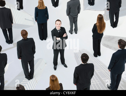 Imprenditore ambizioso in piedi fuori dalla folla Foto Stock