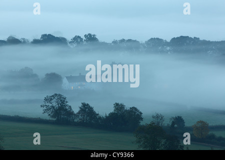 Casa di nebbia al tramonto. Somerset. In Inghilterra. Regno Unito. Foto Stock