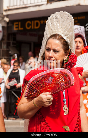 Senior spagnolo lady indossando Mantilla con ventola. Processione religiosa. Fuengirola. Spagna. Foto Stock