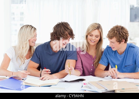 Quattro studenti ridendo come funzionano insieme Foto Stock
