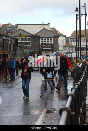 Famiglia a piedi lungo la strada in un giorno di pioggia in St Ives Cornwall, Regno Unito Inghilterra Ottobre 2012 Foto Stock