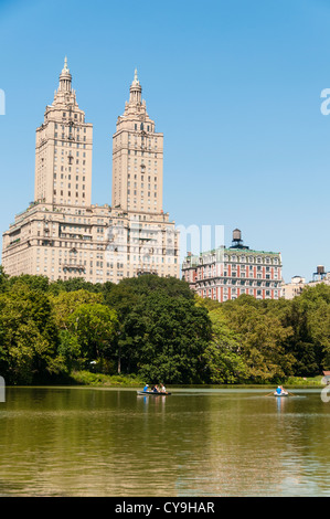 Vista su acqua in Central Park alla storica San Remo edifici durante la tarda estate in un giorno caldo e soleggiato in New York City. Foto Stock