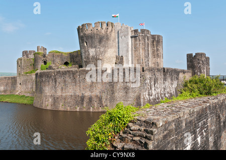 Il Galles, Castello di Caerphilly, iniziò la costruzione del 1268, Fossato, bandiere Gallese Foto Stock