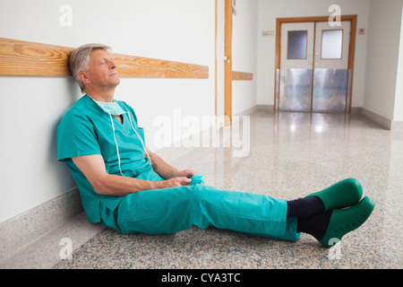 Medico è seduto sul pavimento gli occhi chiusi Foto Stock