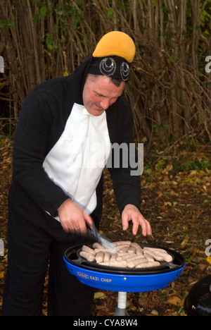 Il carnevale goer preparare le salsicce sul barbecue a Liphook Carnevale, Liphook, Hampshire, Regno Unito. Sabato 27.10.2012. Foto Stock