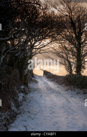 Vicolo del paese coperto di neve, con le vie che portano fino alla collina. Foto Stock