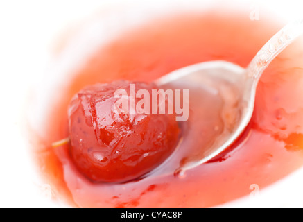 Piccolo cinese rosso Apple in una jam session con cucchiaio in metallo Foto Stock