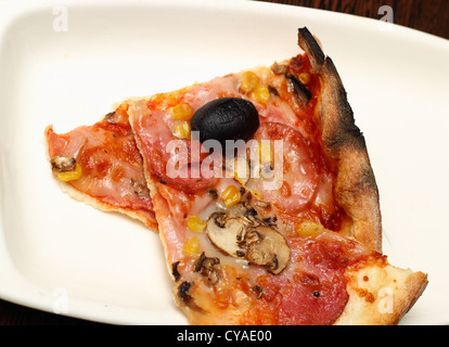 Due fette di pizza su una piastra bianca pronto a mangiare Foto Stock