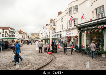 WELLS, Inghilterra: Lo storico mercato di Wells, situato nel cuore della città. Circondato da edifici medievali e dall'iconica cattedrale di Wells, il mercato presenta bancarelle che vendono prodotti locali, artigianato e merci. L'atmosfera vivace e l'affascinante architettura lo rendono una destinazione popolare sia per la gente del posto che per i visitatori. Foto Stock