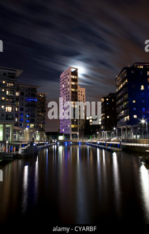 Clarence Dock a Leeds, West Yorkshire durante la notte.con la luna brilla attraverso la torre. Foto Stock
