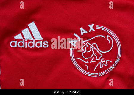 Logo Adidas e Ajax Amsterdam loghi su red football shirt Foto Stock