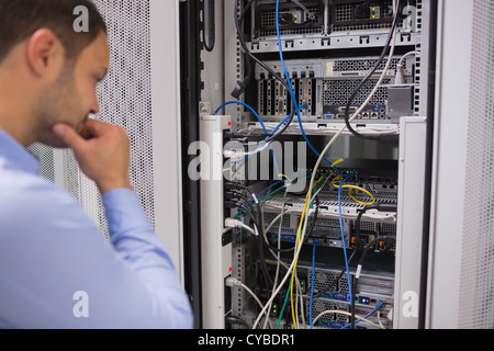 Uomo che guarda i server montati su rack Foto Stock