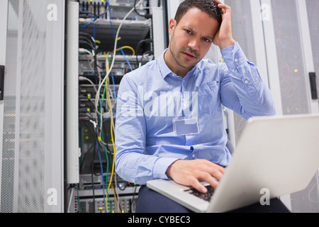 Il tecnico di ottenere frustrati con laptop sui server Foto Stock