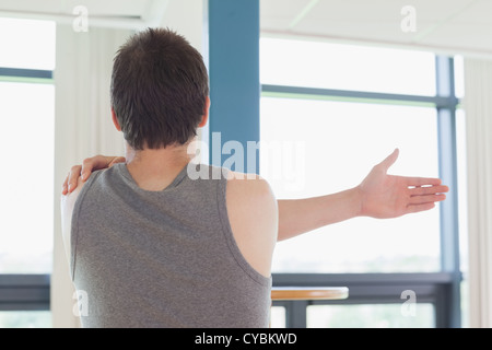L uomo lo stiramento in palestra Foto Stock