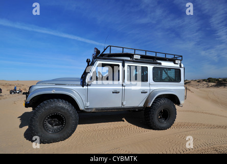 Off road expedition preparato 2012 Land Rover Defender 110 con pneumatici a palloncino, verricello roll cage, luci spot su sabbia in Marocco Foto Stock