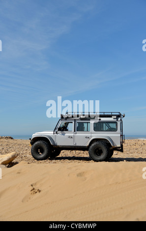 Off road expedition preparato 2012 Land Rover Defender 110 con pneumatici a palloncino, verricello roll cage, luci spot su sabbia in Marocco Foto Stock