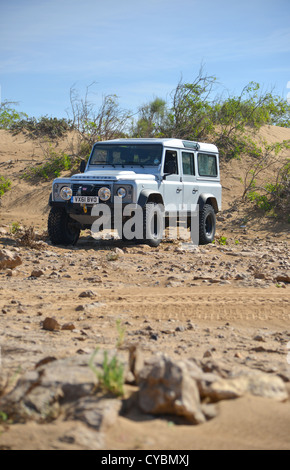 Off road expedition preparato 2012 Land Rover Defender 110 con pneumatici a palloncino, verricello roll cage, luci spot su sabbia in Marocco Foto Stock