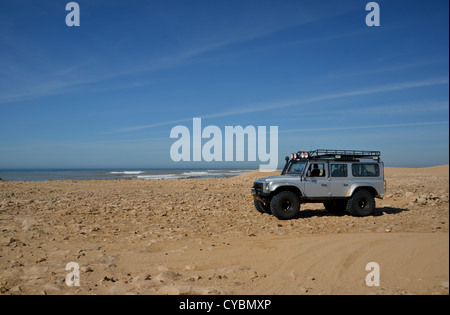 Off road expedition preparato 2012 Land Rover Defender 110 con pneumatici a palloncino, verricello roll cage, luci spot su sabbia in Marocco Foto Stock