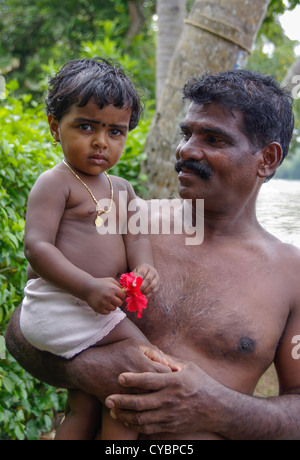 Un papà orgoglioso tiene il suo bambino nelle lagune del Kerala India Foto Stock