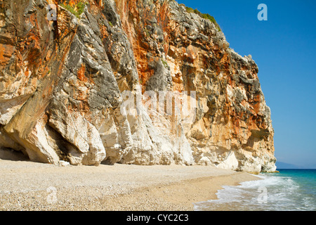 Bella e soleggiata spiaggia circondata da alta scogliera Foto Stock