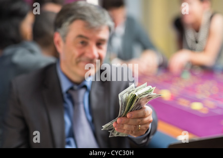 L'uomo tenendo fuori il denaro Foto Stock