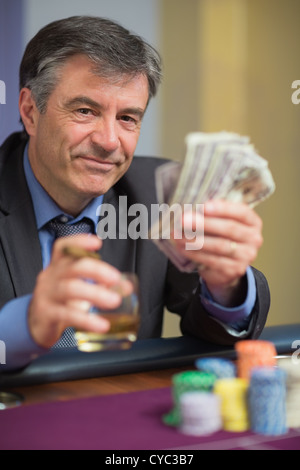Uomo con soldi e sorridente Foto Stock