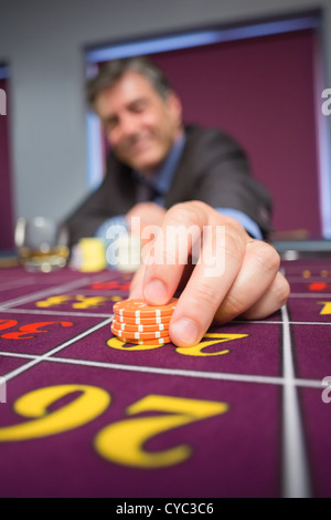 L'uomo immissione puntata alla roulette Foto Stock