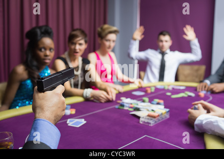 L'uomo puntando la pistola contro un altro uomo con le mani in alto Foto Stock