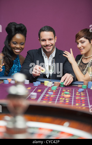 L'uomo gioca alla roulette con due donne Foto Stock