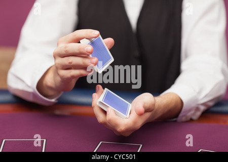 Il concessionario shuffling mazzo di carte in un casinò Foto Stock