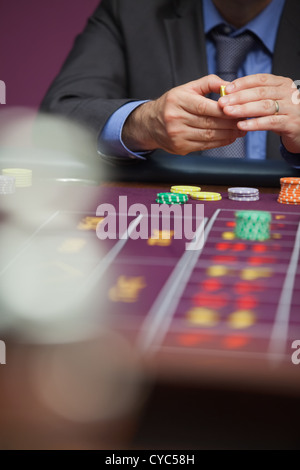 L'uomo immissione puntata alla roulette Foto Stock