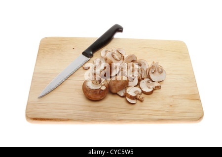 Intero e fette di funghi castagne su una tavola di legno con un coltello isolata contro bianco Foto Stock