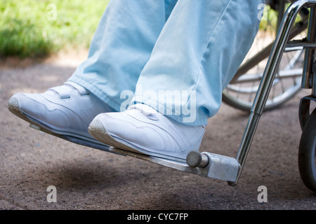 Senior donna su una sedia a rotelle, gambe e piedi solo Foto Stock