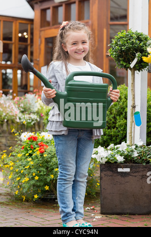 Little Girl holding annaffiatoio mentre sorridente Foto Stock