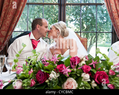 La sposa e lo sposo di condividere un bacio sulla loro giorno di nozze Foto Stock