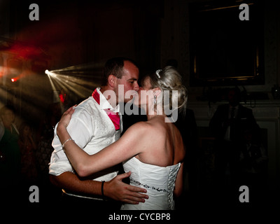 La sposa e lo sposo bacio romanticamente durante il primo ballo il loro giorno delle nozze. Foto Stock