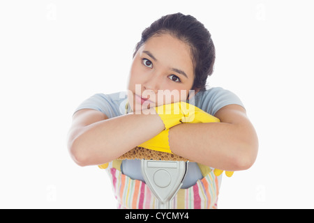 Triste donna appoggiata sul mop Foto Stock